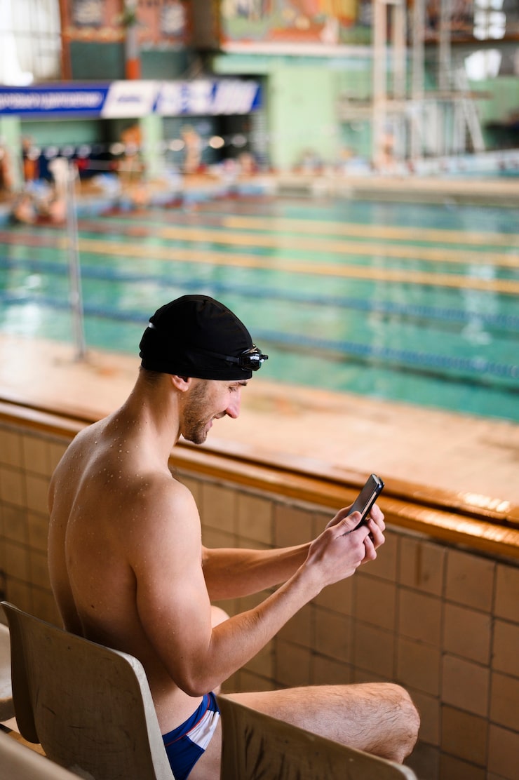 smiley-male-swimmer-using-mobile_23-2148357052